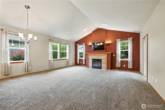 a view of empty room with a fireplace and windows