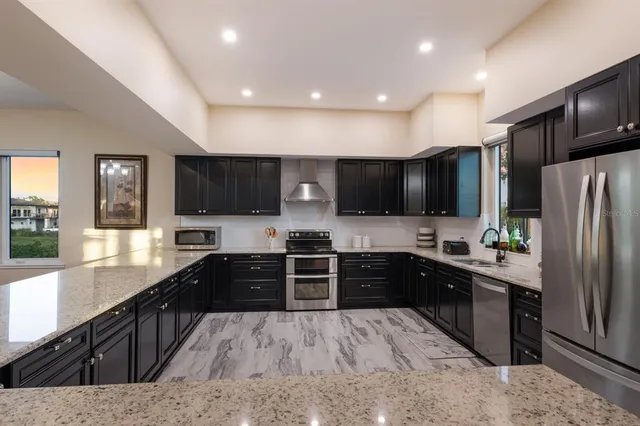a kitchen with granite countertop a sink cabinets and stainless steel appliances