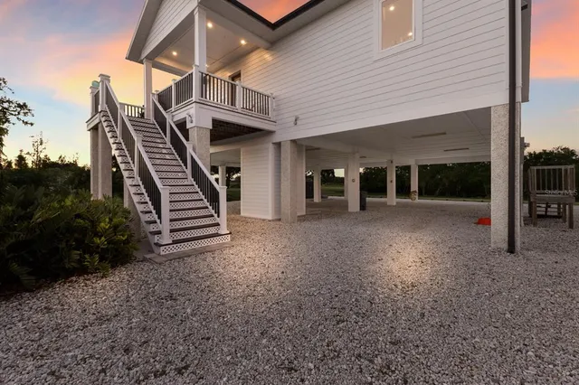 a view of a house with stairs and wooden fence