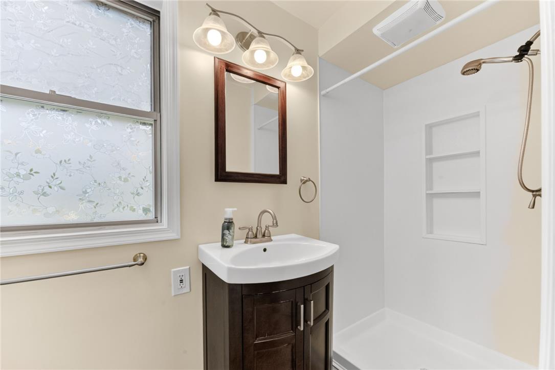 1166 Stones Crossing Road Easton, PA 18045 - Photo 8 of 35 A well-appointed bathroom features a dark wood vanity, modern sink, and a convenient walk-in shower.