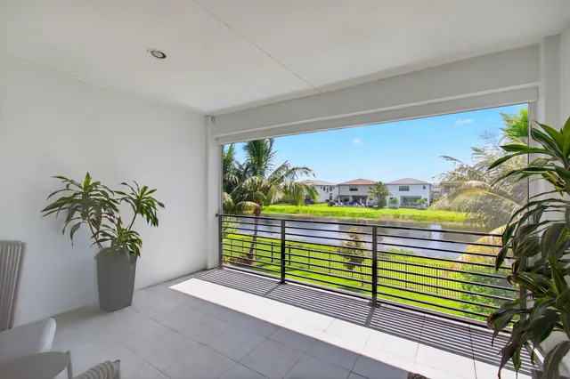 a living room with furniture a rug and a floor to ceiling window