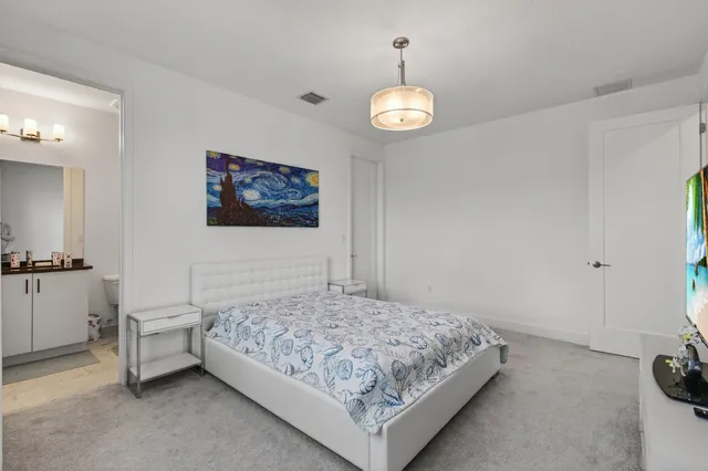 a view of a swimming pool with a lawn chairs under palm trees