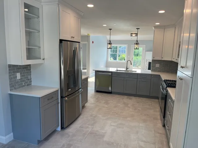 a kitchen with stainless steel appliances granite countertop a refrigerator and a sink