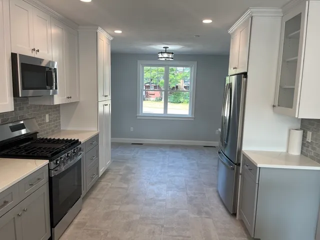 a view of an empty room with a kitchen