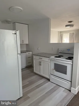 a kitchen with white cabinets and white appliances