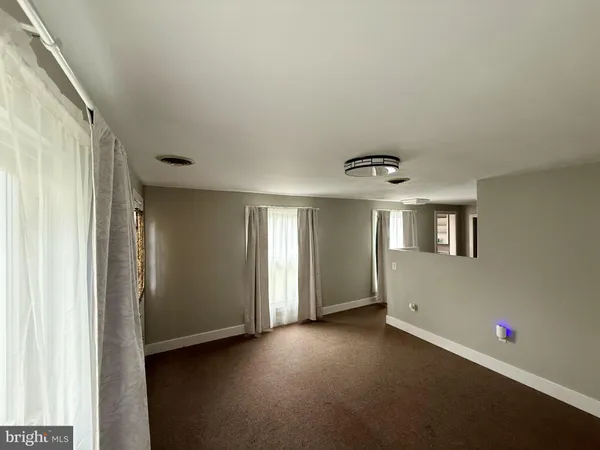 an empty room with windows and closet