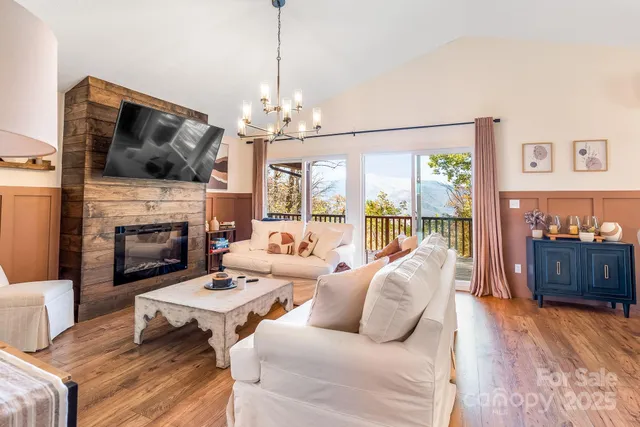 a living room with furniture a chandelier and a large window