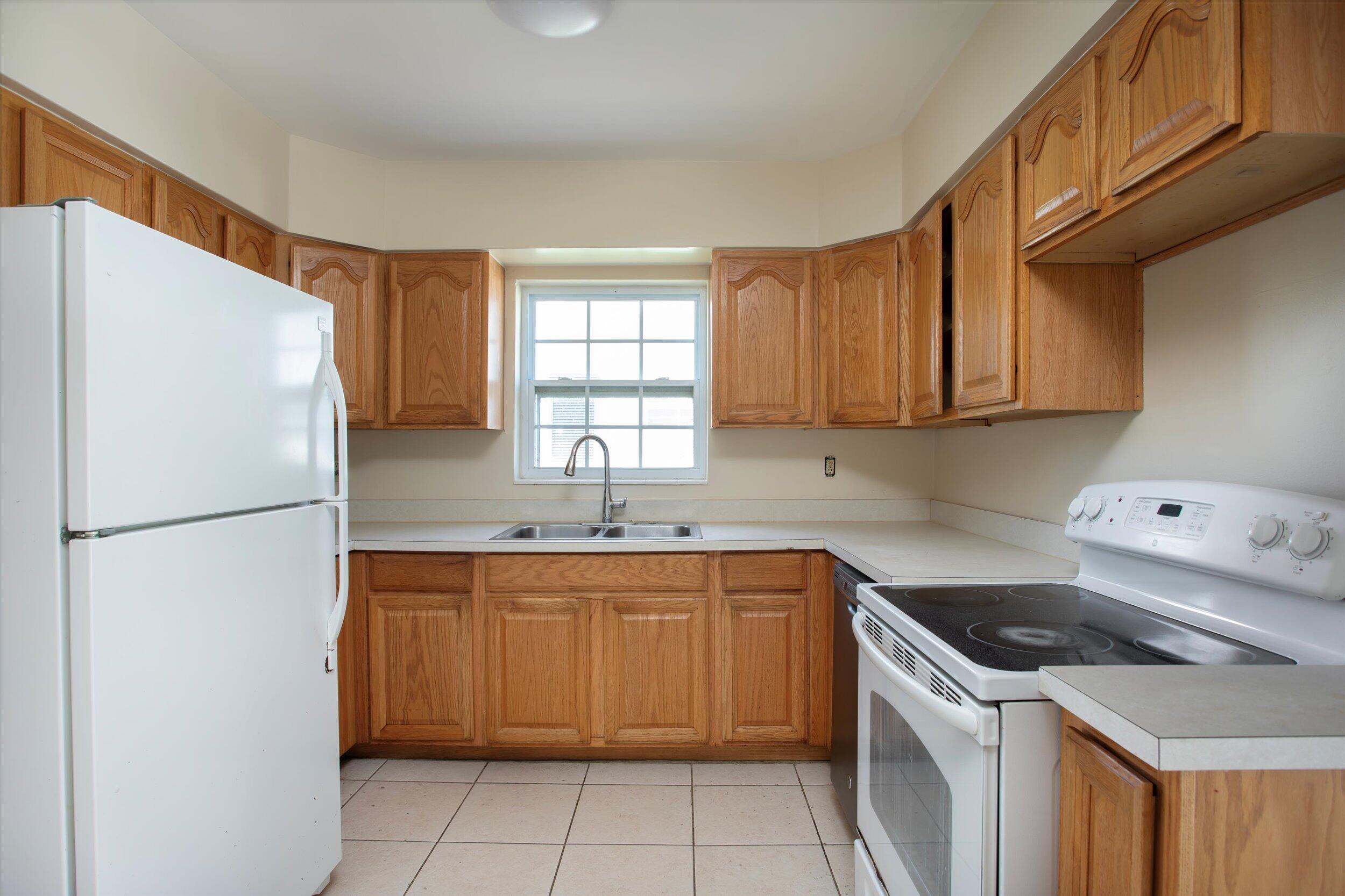 74 Key Haven Road Key West, FL 33040 - Photo 13 of 28 a kitchen with a sink a refrigerator and cabinets