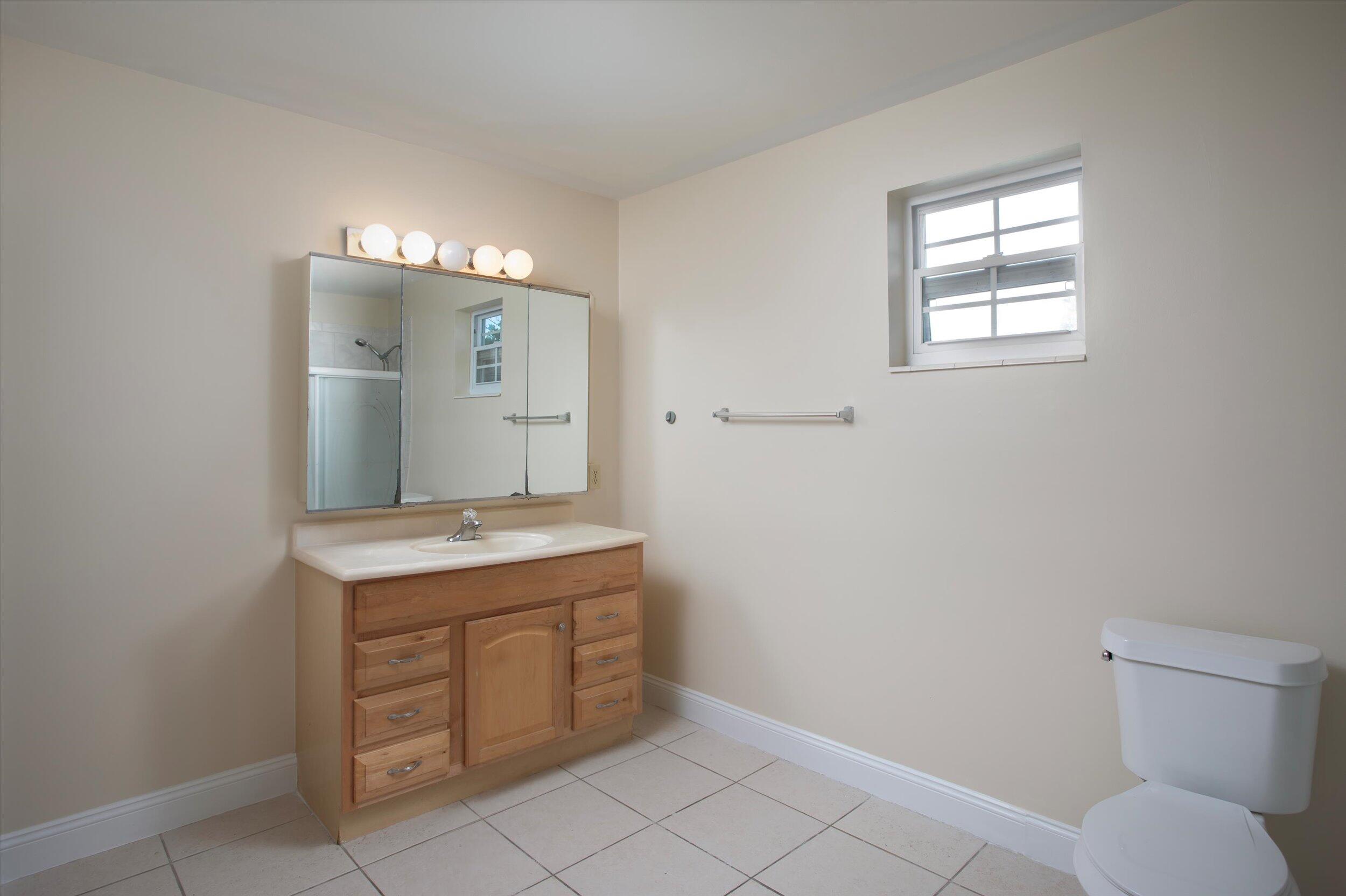 74 Key Haven Road Key West, FL 33040 - Photo 17 of 28 a bathroom with a granite countertop sink toilet and mirror