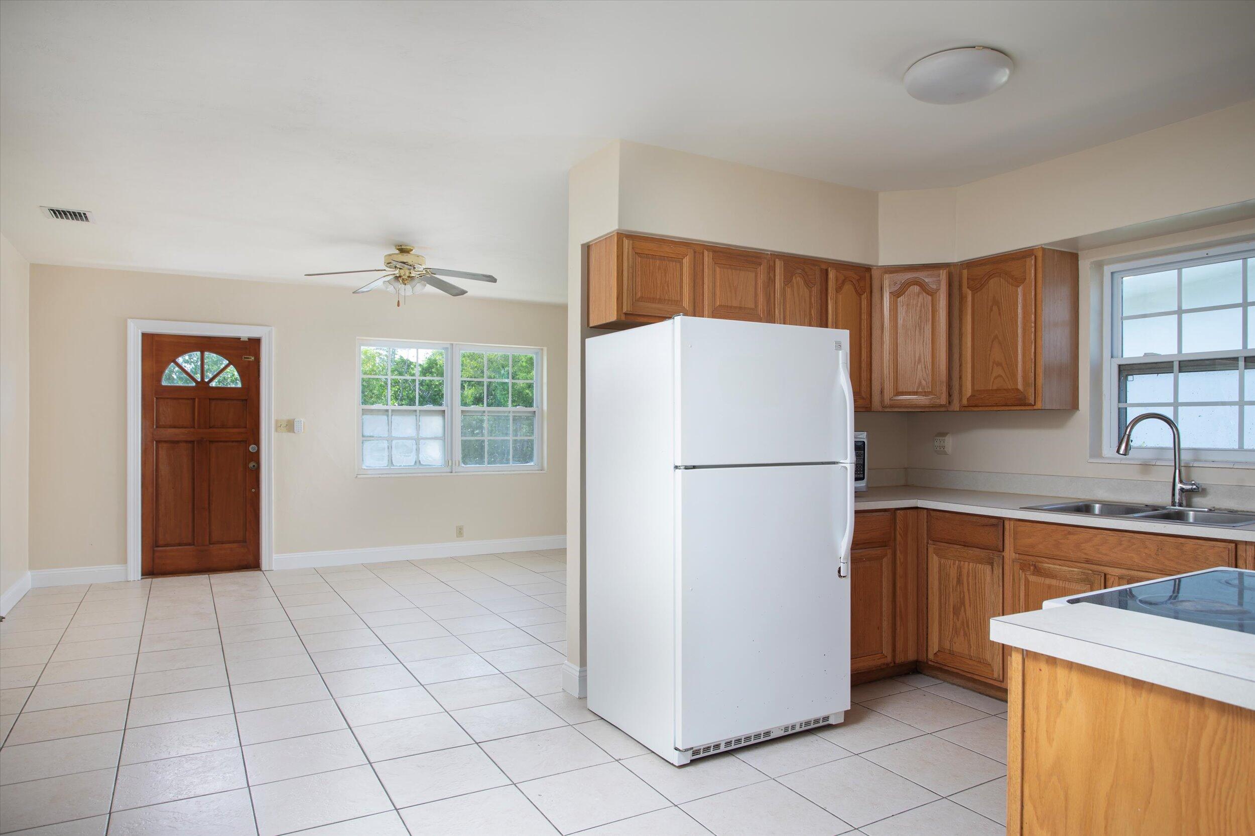 74 Key Haven Road Key West, FL 33040 - Photo 4 of 28 a white refrigerator freezer sitting inside of a kitchen with granite countertop cabinets and a sink