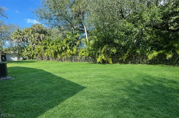 a view of green field with trees in the background