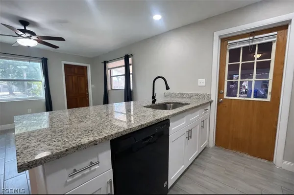 a kitchen with granite countertop cabinets a sink a window and stainless steel appliances