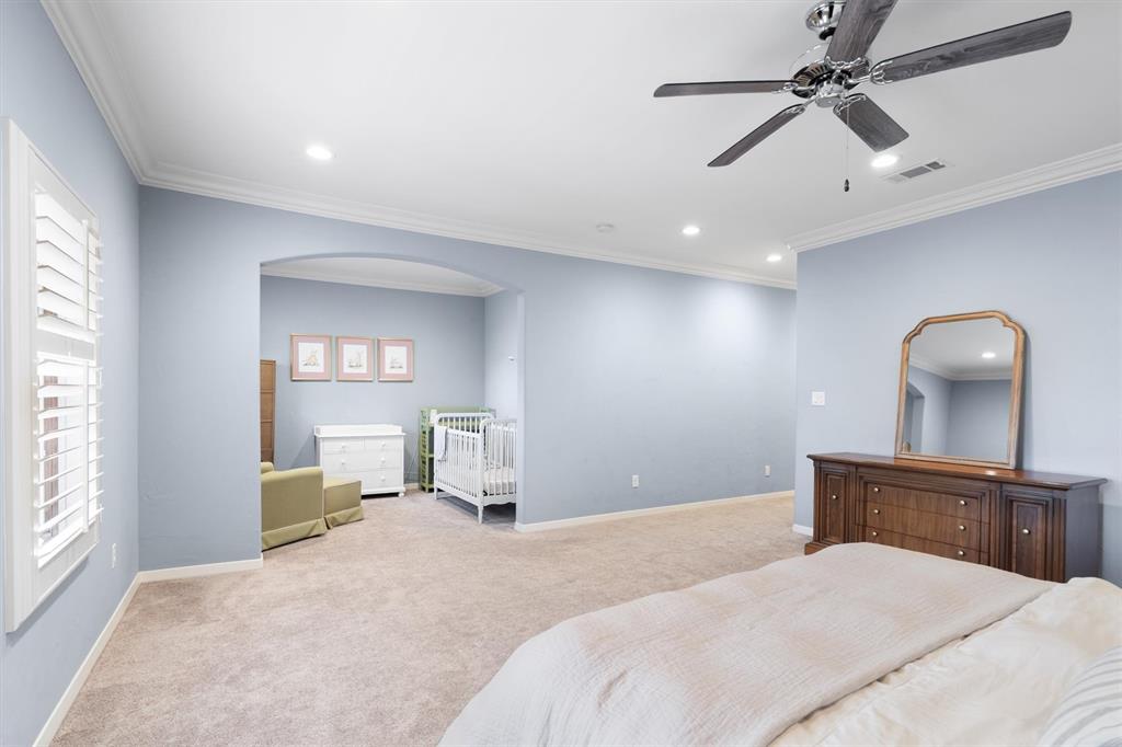 4323 Gilbert Avenue, Unit 4 Dallas, TX 75219 - Photo 29 of 40 a bedroom with a bed and a chandelier