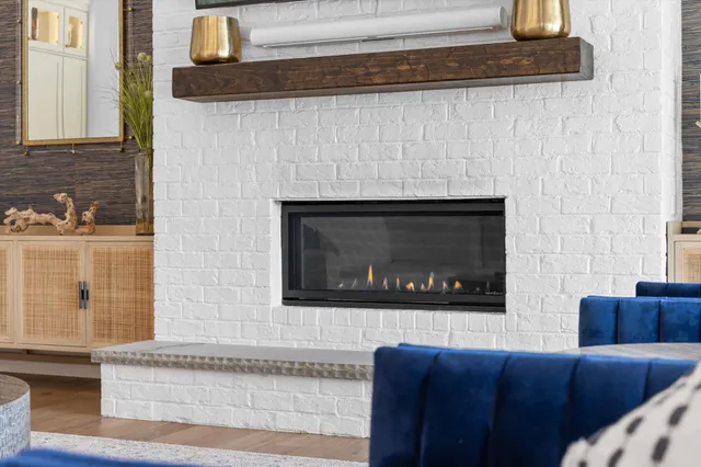 a living room with furniture a chandelier and a fireplace