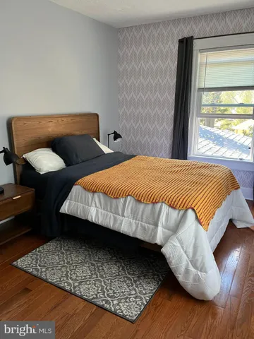 a bed sitting in a bedroom next to a window