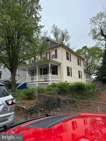 a view of a white house with large windows and a large tree