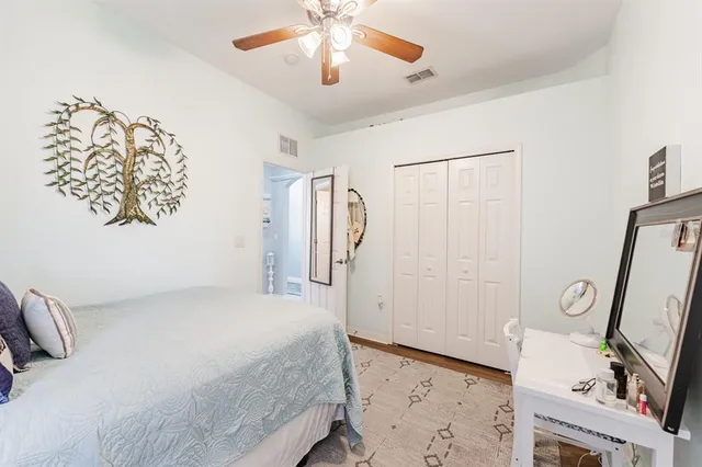 a bedroom with a bed and a mirror on the dresser