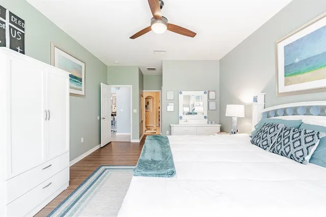 a spacious bedroom with a large bed and a chandelier