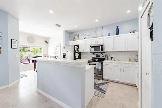 a kitchen with white cabinets and stainless steel appliances