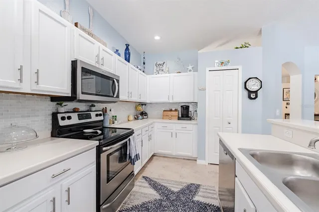 a kitchen with granite countertop a sink a stove and cabinets