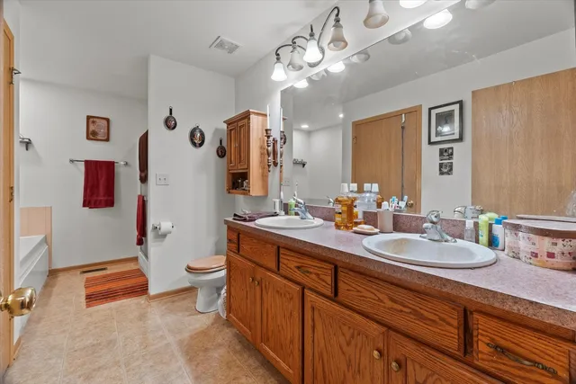 a bathroom with a double vanity sink mirror and toilet