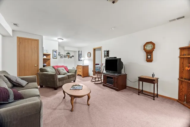 a living room with furniture a flat screen tv and a window