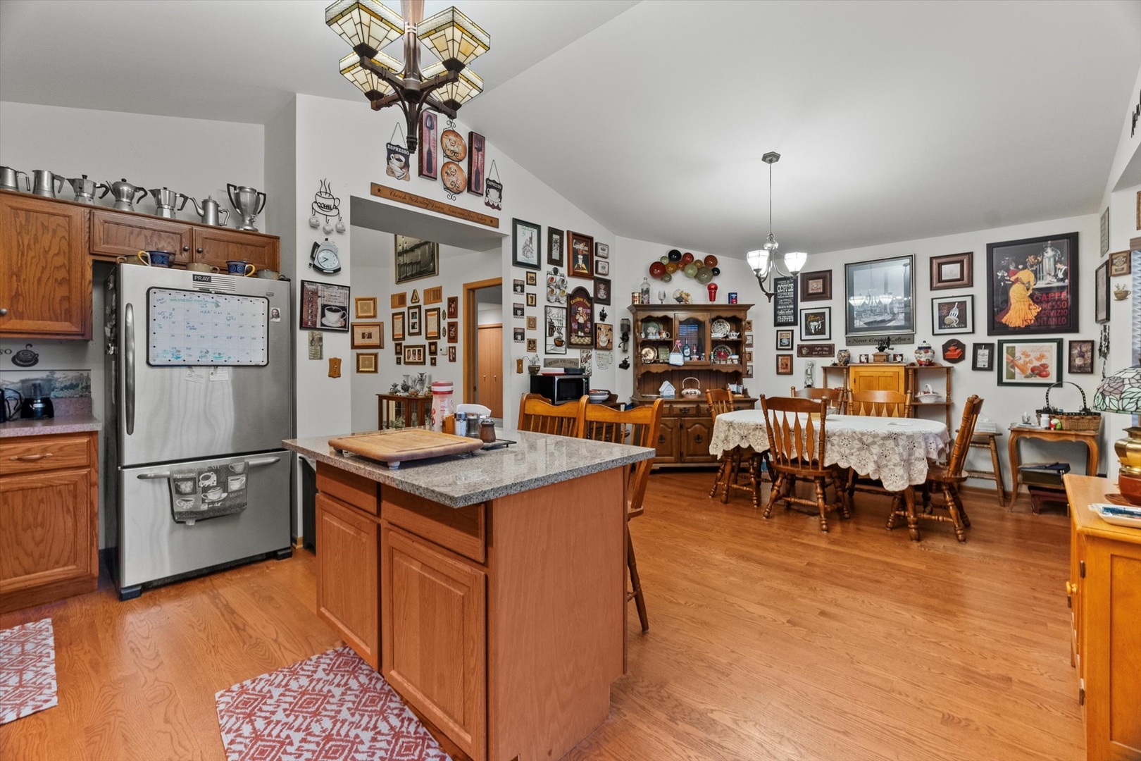 25426 Barrow Road Manhattan, IL 60442 - Photo 7 of 30 a kitchen with stainless steel appliances granite countertop a refrigerator a sink dishwasher a dining table and chairs with wooden floor