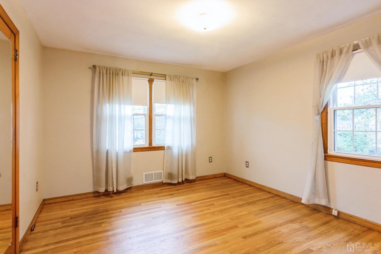 168 Dunhams Corner Road East Brunswick, NJ 08816 - Photo 18 of 30 Master Bedroom with large windows (Floors are now a lighter color as they have been freshly polished)