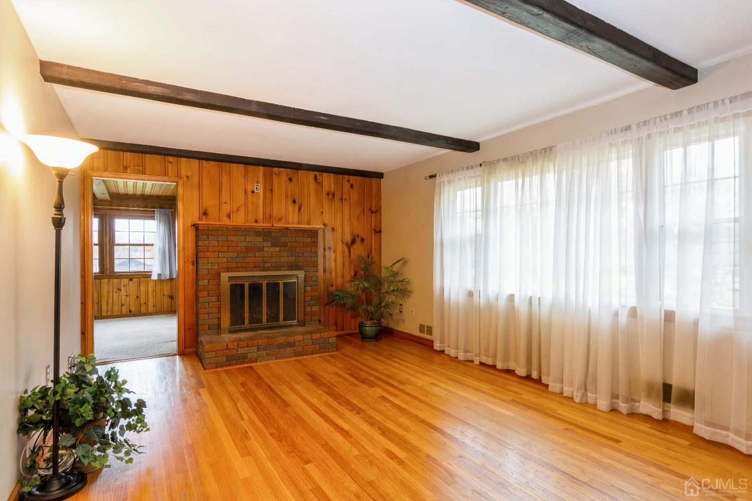 168 Dunhams Corner Road East Brunswick, NJ 08816 - Photo 4 of 30 Living room with wood burning fireplace has tons of natural sunlight pouring in! Floors are now a lighter color as they have been freshly polished.
