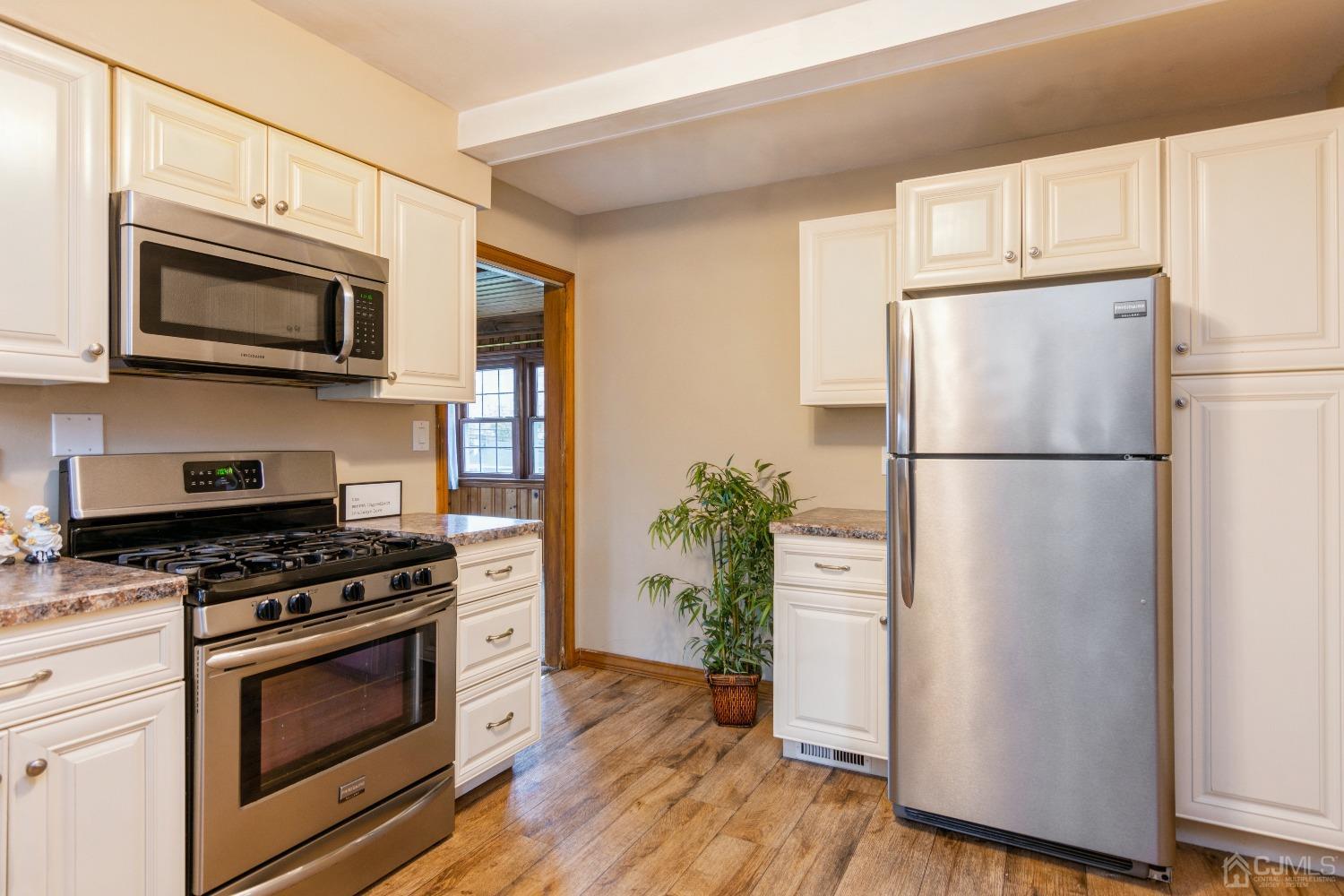 168 Dunhams Corner Road East Brunswick, NJ 08816 - Photo 10 of 30 Kitchen with white cabinets and stainless steel appliances including gas cooking range/oven