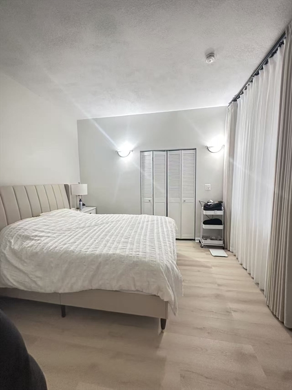 1423 Commonwealth Avenue, Unit 202 Boston, MA 02135 - Photo 3 of 6 a spacious bedroom with a bed and a walk in closet