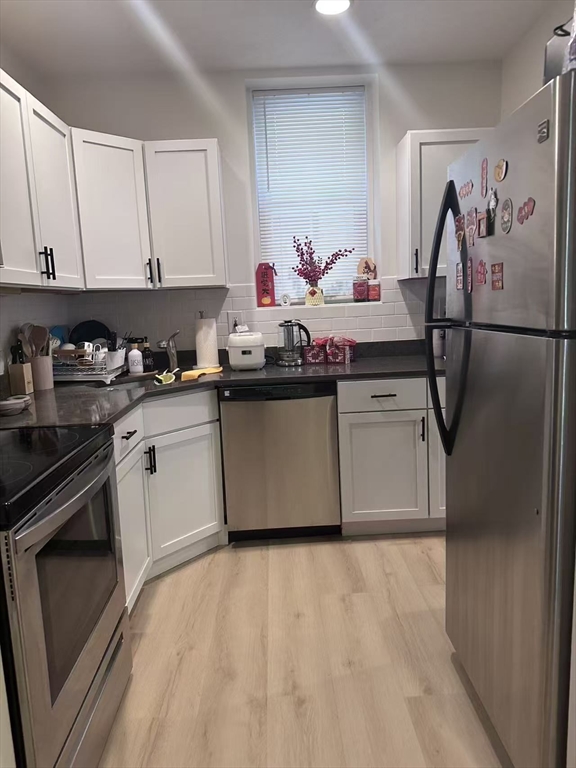 1423 Commonwealth Avenue, Unit 202 Boston, MA 02135 - Photo 4 of 6 a kitchen with stainless steel appliances granite countertop a stove a sink dishwasher and a refrigerator