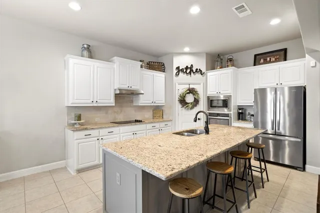 a large white kitchen with stainless steel appliances