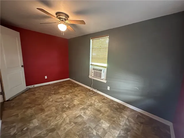 an empty room with windows and fan