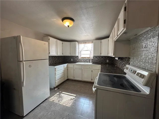 a kitchen with a refrigerator sink and cabinets