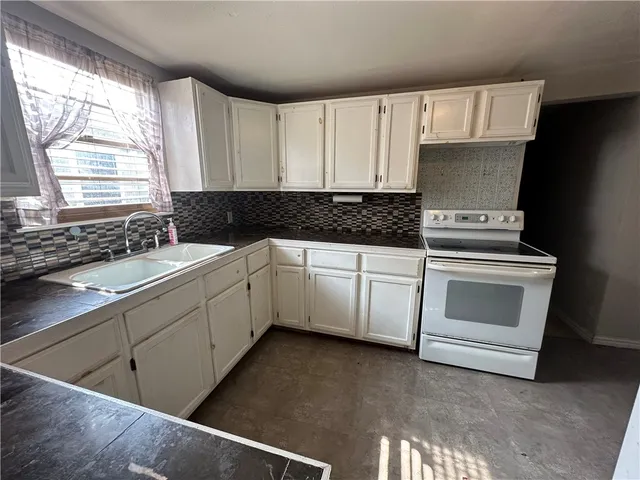a kitchen with granite countertop white cabinets and white appliances