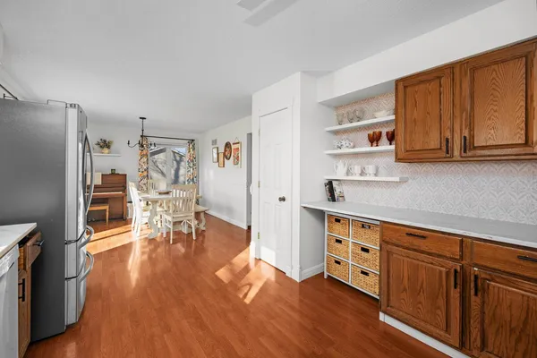 a kitchen with stainless steel appliances granite countertop a refrigerator a stove oven and white cabinets with wooden floors