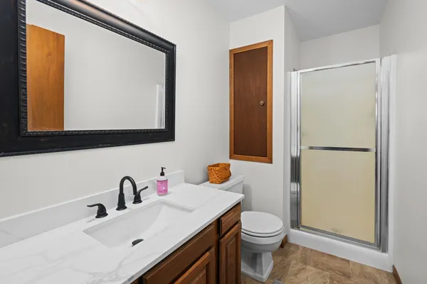 a bathroom with a sink vanity mirror and toilet