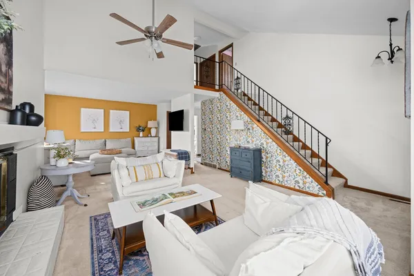 a living room with couches a flat screen tv and a dining table with garden view