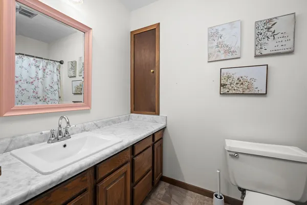 a bathroom with a granite countertop sink a toilet and a mirror