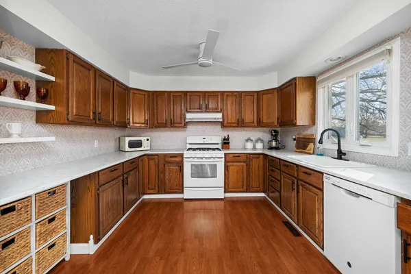 a kitchen with wooden floors wooden cabinets and stainless steel appliances