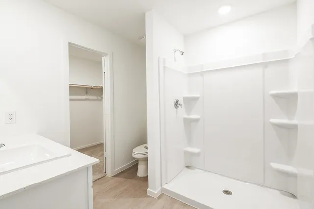 a bathroom with a sink a toilet and shower