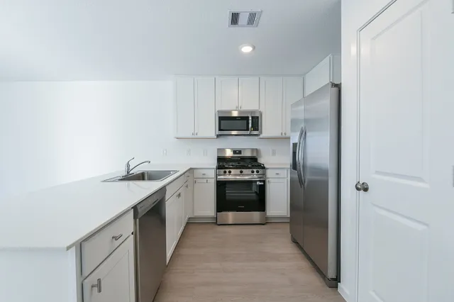 a kitchen with a sink a refrigerator and a stove
