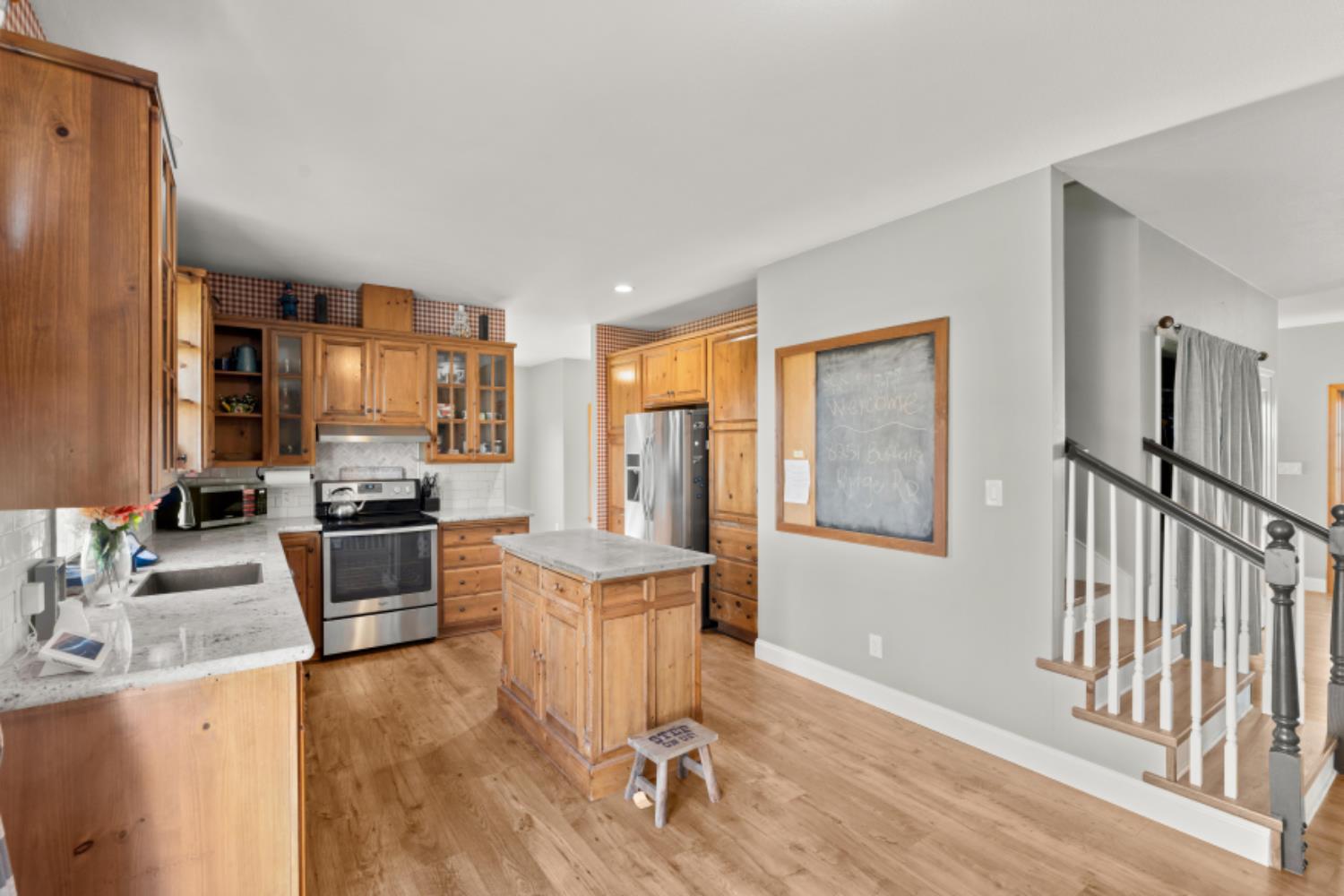 8251 Buffalo Ridge Road Ione, CA 95640 - Photo 22 of 75 a kitchen with granite countertop a stove and a wooden floors