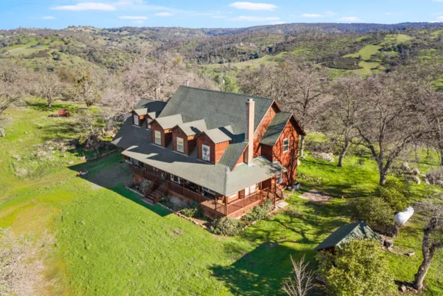 an aerial view of a house with yard swimming pool and mountains