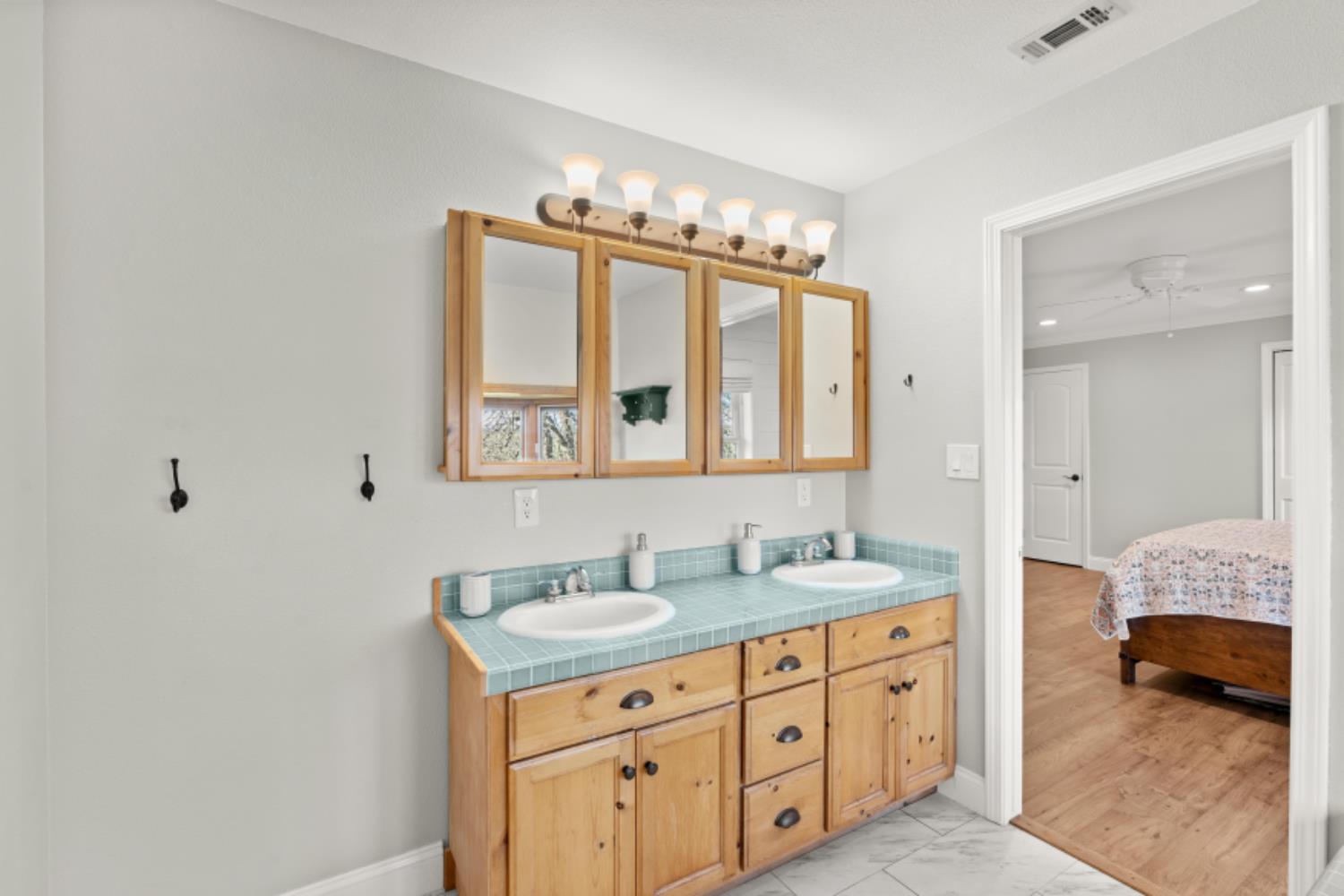 8251 Buffalo Ridge Road Ione, CA 95640 - Photo 41 of 75 a en suite bathroom with double sink and a mirror