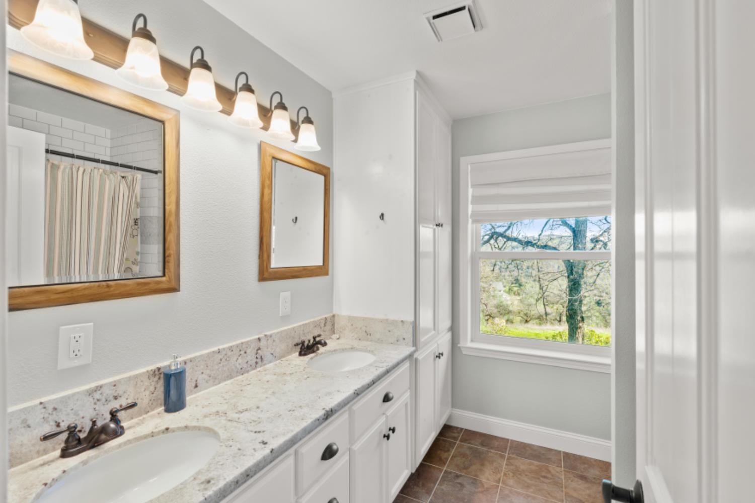 8251 Buffalo Ridge Road Ione, CA 95640 - Photo 44 of 75 a bathroom with a granite countertop sink and a mirror