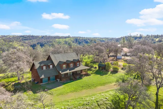 an aerial view of a house with a yard and lake view