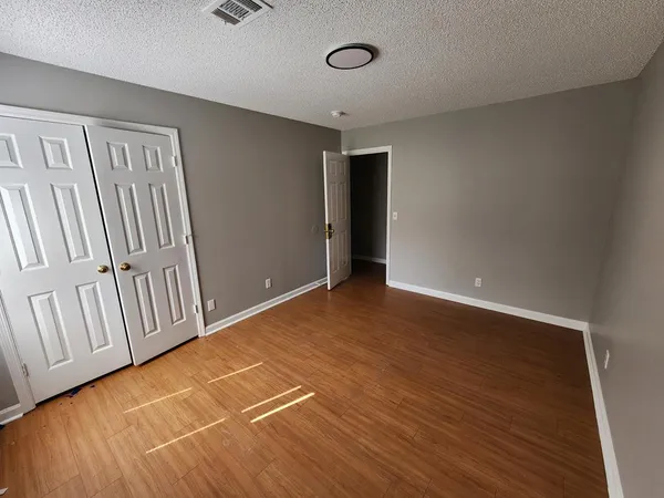 a view of an empty room with wooden floor