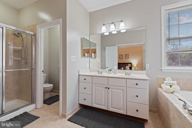 a kitchen with stainless steel appliances kitchen island granite countertop a table chairs and a refrigerator